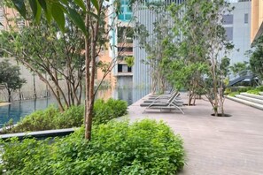 A serene outdoor area with a water feature, seating, and greenery. - Bukit Bintang Lalaport Designer Studio KLCC View (Kuala Lumpur)