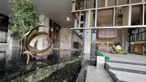 A modern lobby with a central water feature, a spiral sculpture, and a staircase. - Bukit Bintang Lalaport Designer Studio KLCC View (Kuala Lumpur)