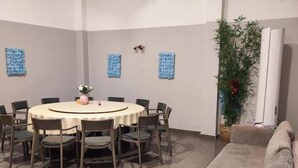 A dining area with a round table and chairs, a sofa, and decorative wall art. - Jinhui Hotel (Casablanca)