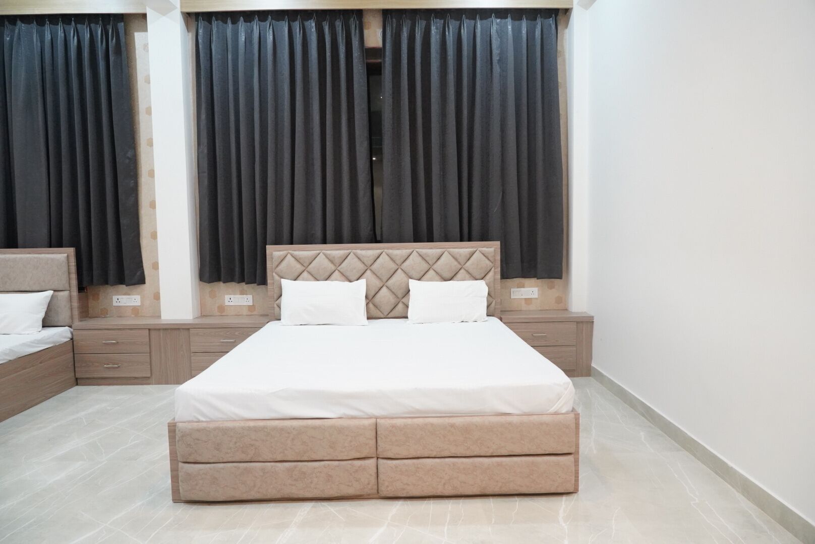 Un dormitorio con cama, mesitas de noche y cómoda.