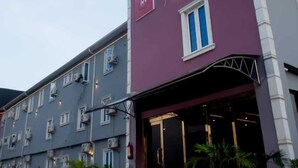 A multi-story hotel with a purple and grey facade, large windows, and a sign indicating 'Ivy'. - Ivy Hotel Epe (Epe)