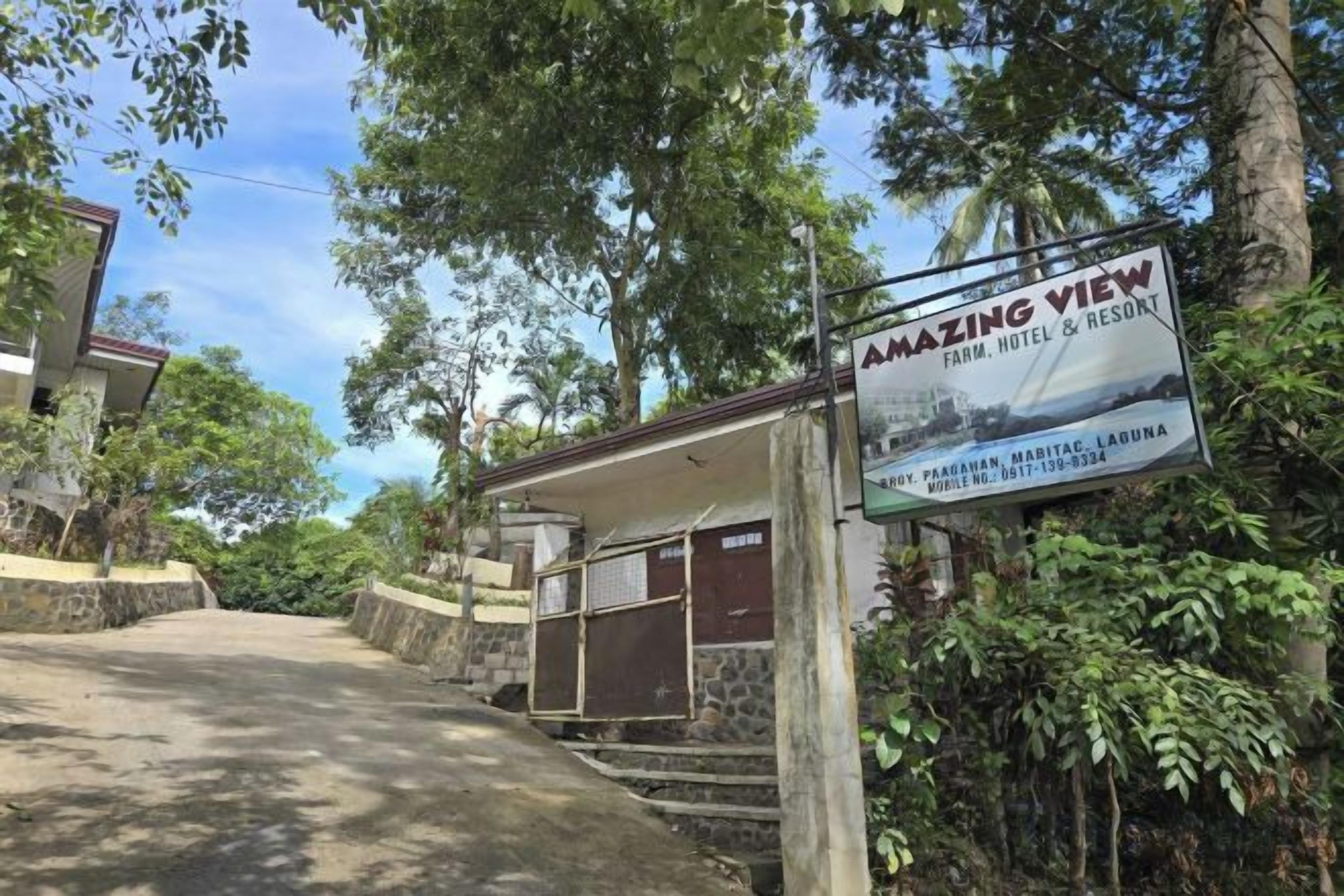 A sign for 'AMAZING VIEW FARM HOTEL & RESORT' with a view of the surrounding landscape.