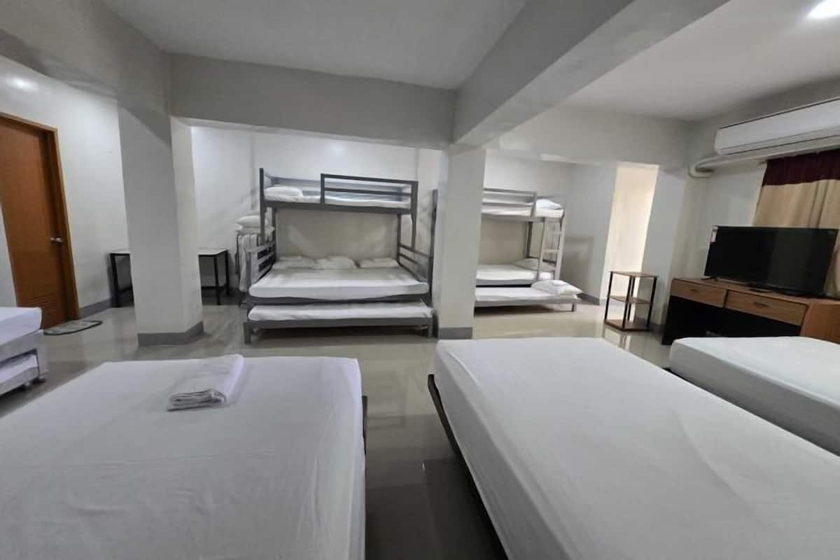 Una habitación de hotel con literas, televisión y escritorio.