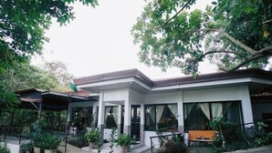 A modern house with a covered porch, potted plants, and a bench. - Amazing View Mountain Resort Laguna (Mabitac)