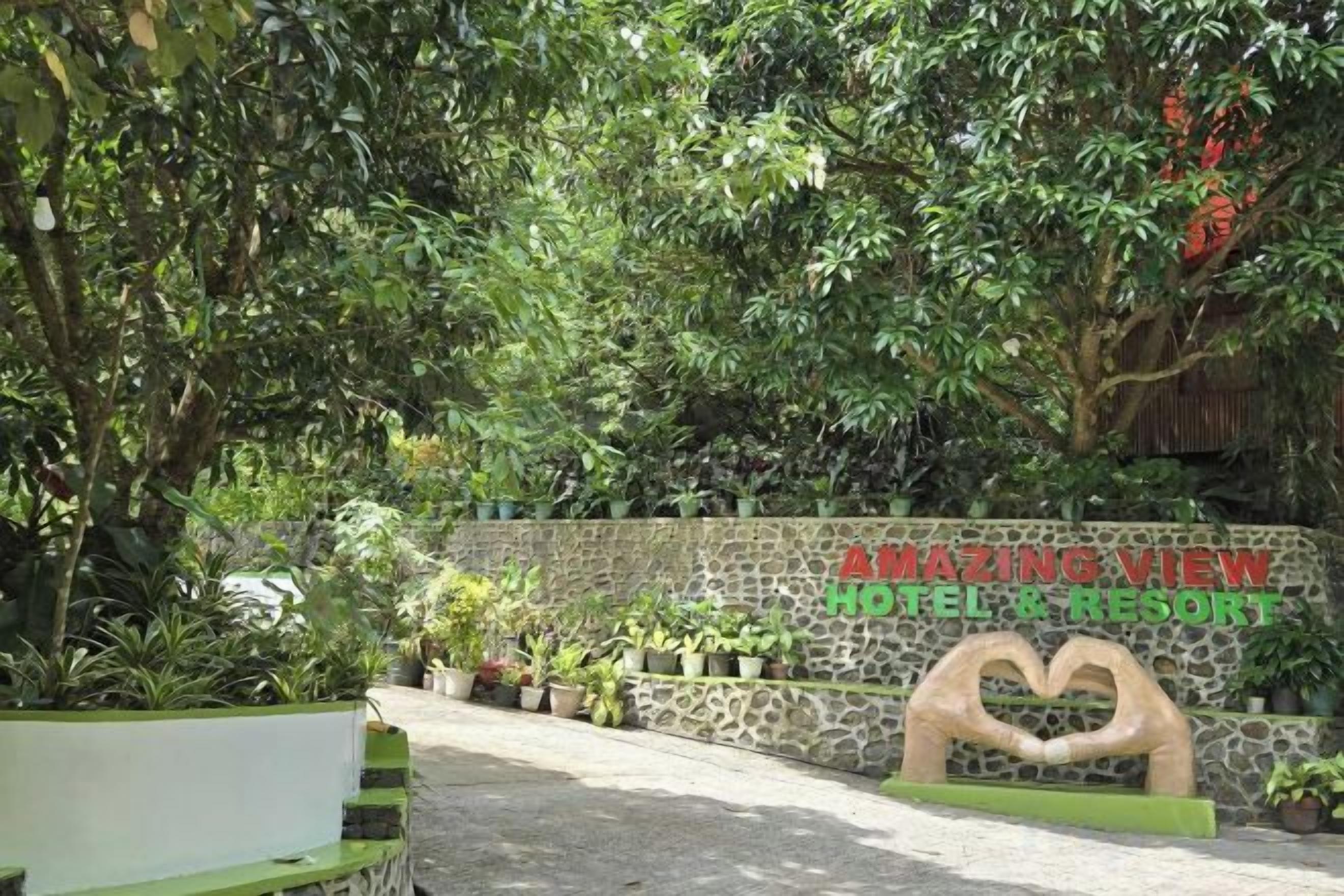 A stone wall with a heart-shaped cutout and the text 'AMAZING VIEW HOTEL & RESORT' in red.