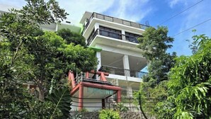 A multi-story building with balconies, surrounded by lush greenery. - Amazing View Mountain Resort Laguna (Mabitac)