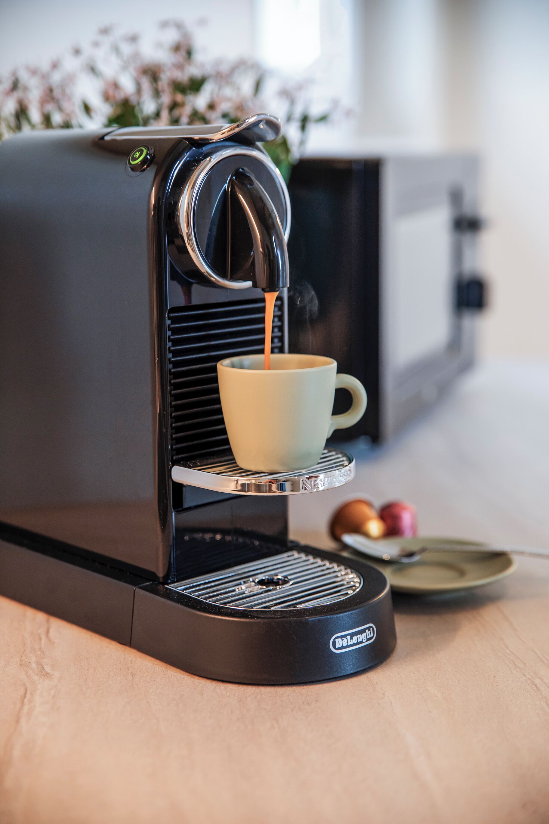 A DeLonghi espresso machine dispensing coffee into a cup.