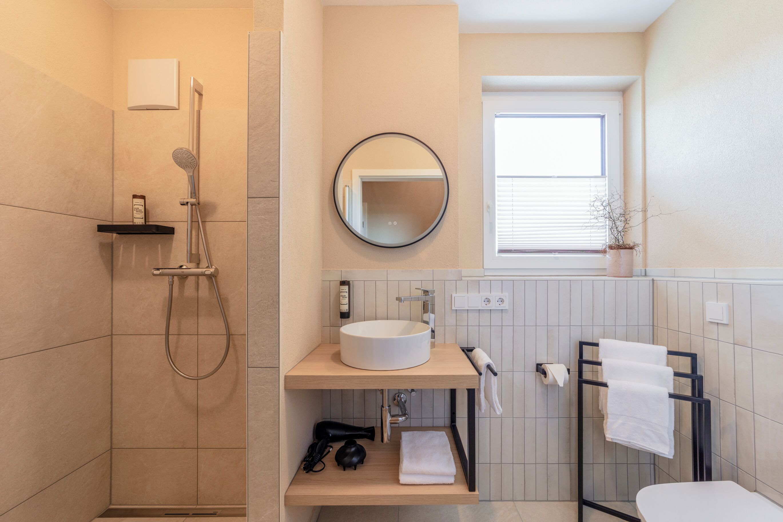 Ein modernes Badezimmer mit Dusche, Waschbecken und Toilette.