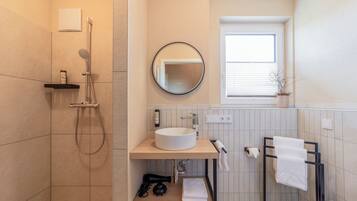 Ein modernes Badezimmer mit Dusche, Waschbecken und Toilette.