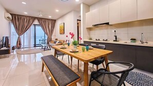 A modern kitchen with a dining area, a bench, and a view through the window. - Danga Bay Country Garden by RR JBcity (Johor Bahru)