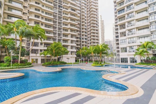 Une piscine entourée d’immeubles résidentiels de grande hauteur, dotés de balcons.