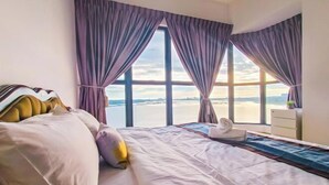A hotel room with a bed, a view of the sea, and a window with curtains. - Danga Bay Country Garden by RR JBcity (Johor Bahru)