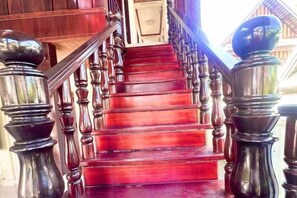 Un escalier en bois, doté d’une main courante et de balustres, menant à l’étage supérieur.