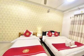 Een hotelkamer met twee bedden, elk met een rood-witte spreideken, en een gordijn voor het raam.
