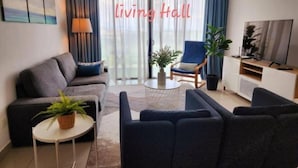A living room with a sofa, armchair, coffee table, and a TV stand. - Conezion at Putrajaya #IOI CITY MALL #7 Pax #NEW (Serdang)