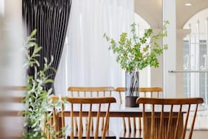 A dining area with a table, chairs, and a potted plant. - VietHOME - 22 Pho Hue - Apartment 502 (Hanoi)