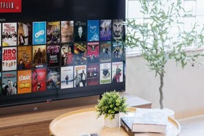 A flat-screen TV displaying a selection of movies and TV shows. - VietHOME - 22 Pho Hue - Apartment 502 (Hanoi)