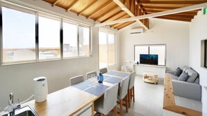 A modern kitchen with a wooden countertop, a built-in sink, and a window overlooking a cityscape. - and SEA The Terrace (Kamogawa)