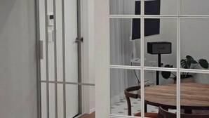 A room with a wooden dining table, chairs, a potted plant, and a television. - Yuyuhi Private Pool Villa (Jeju)