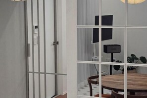 A room with a wooden dining table, chairs, a potted plant, and a television. - Yuyuhi Private Pool Villa (Jeju)