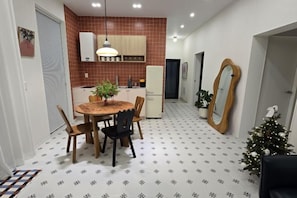 Una cocina compacta con comedor, refrigerador y un árbol de Navidad.