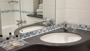 Un baño con dos lavabos, ducha y espejo.