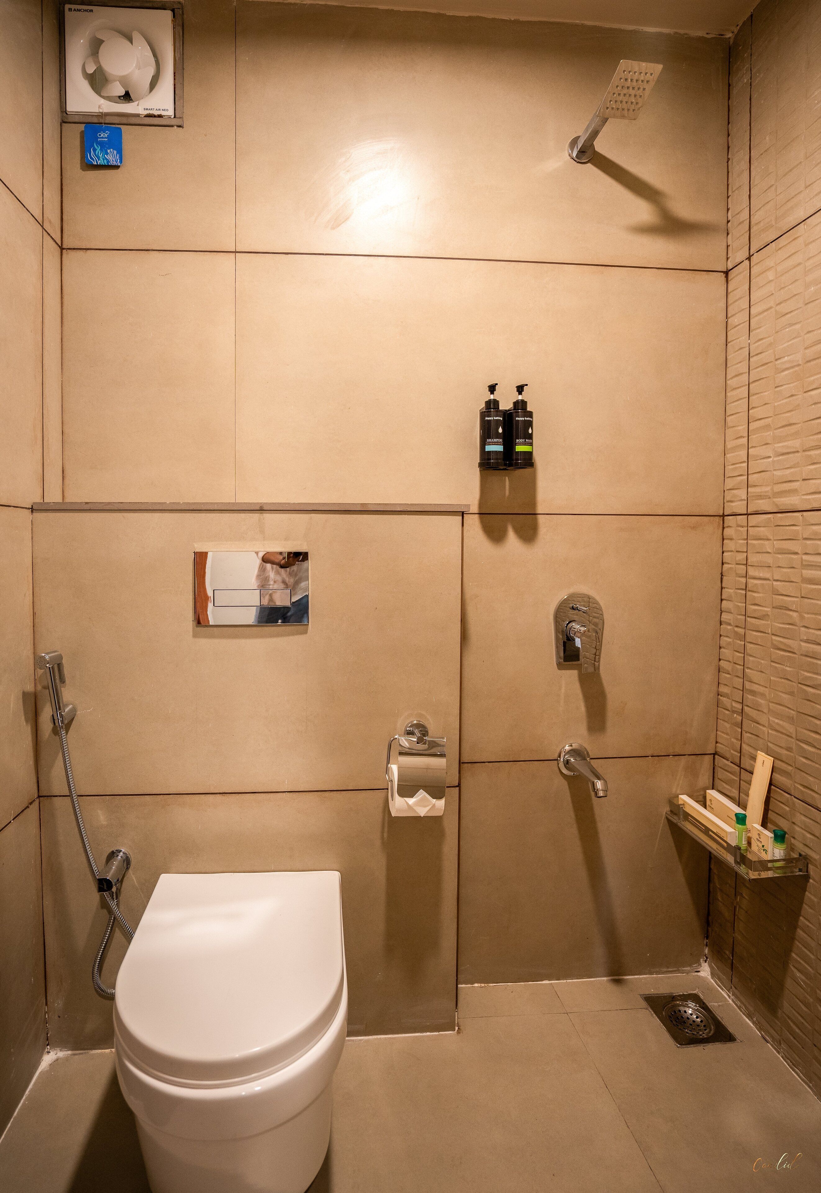 Un baño con inodoro, ducha y toallero.