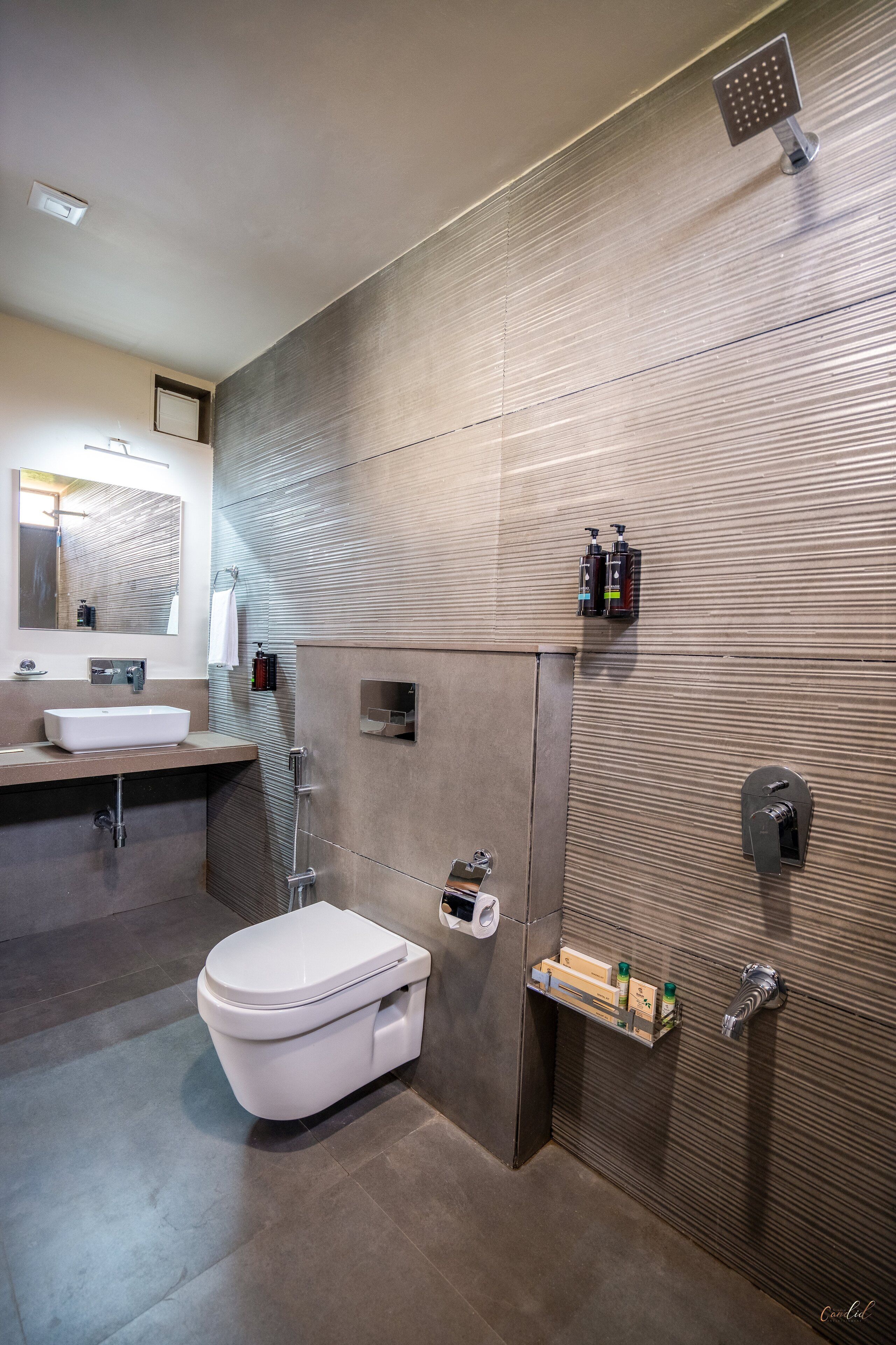 Un bagno moderno con uno specchio grande, un lavandino, un water e una doccia.