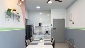 A modern kitchen with white cabinets, a black refrigerator, and a microwave. - Razak City Residences A3 by Favspace (Kuala Lumpur)