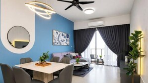 A modern living room with a dining area, a ceiling fan, a large mirror, and a window with curtains. - Bella Vista Silverscape Seaview Homestay (Melaka)