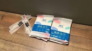 A wooden surface with two packages of disposable bath towels and a smaller package of a different item. - Entire Unit & 2BR Near Legoland (Iskandar Puteri)