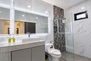 A modern bathroom with a marble vanity, a large mirror, a toilet, and a glass-enclosed shower. - Luxury 3BR Private Pool Villa Near Walking Street Pattaya (Pattaya)