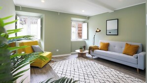 A living room with a light grey sofa, yellow armchair, and a round coffee table. - Amazing Apartment @ Graça, Lisbon (Lisbon)
