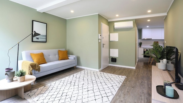 A modern living room with a sofa, a coffee table, and a patterned rug. - Amazing Apartment @ Graça, Lisbon (Lisbon)