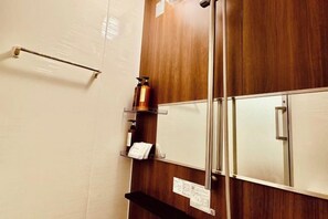 A bathroom with a wooden vanity, a towel rack, and a mirror. - luxuriant flowers (Osaka)