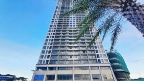 A tall, modern high-rise building with multiple floors and balconies.