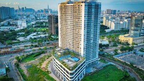 A high-rise building with a rooftop pool and a modern design.
