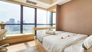 Une chambre avec une grande fenêtre, un lit, un bureau et une chaise.