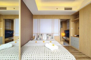 A hotel room with a large bed, a TV, and wooden paneling.