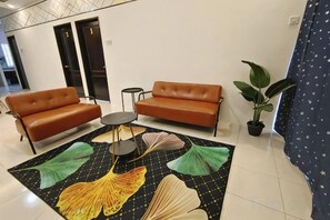 A hotel lobby with a brown sofa set, a small round table, and a potted plant. - Ifloral CH1 (Tanah Rata)