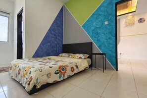 A bedroom with a bed, a nightstand, and a geometric wall design. - Ifloral CH1 (Tanah Rata)
