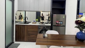 Eine moderne Küche mit Geschirrspüler, Kaffeemaschine und Kühlschrank.
