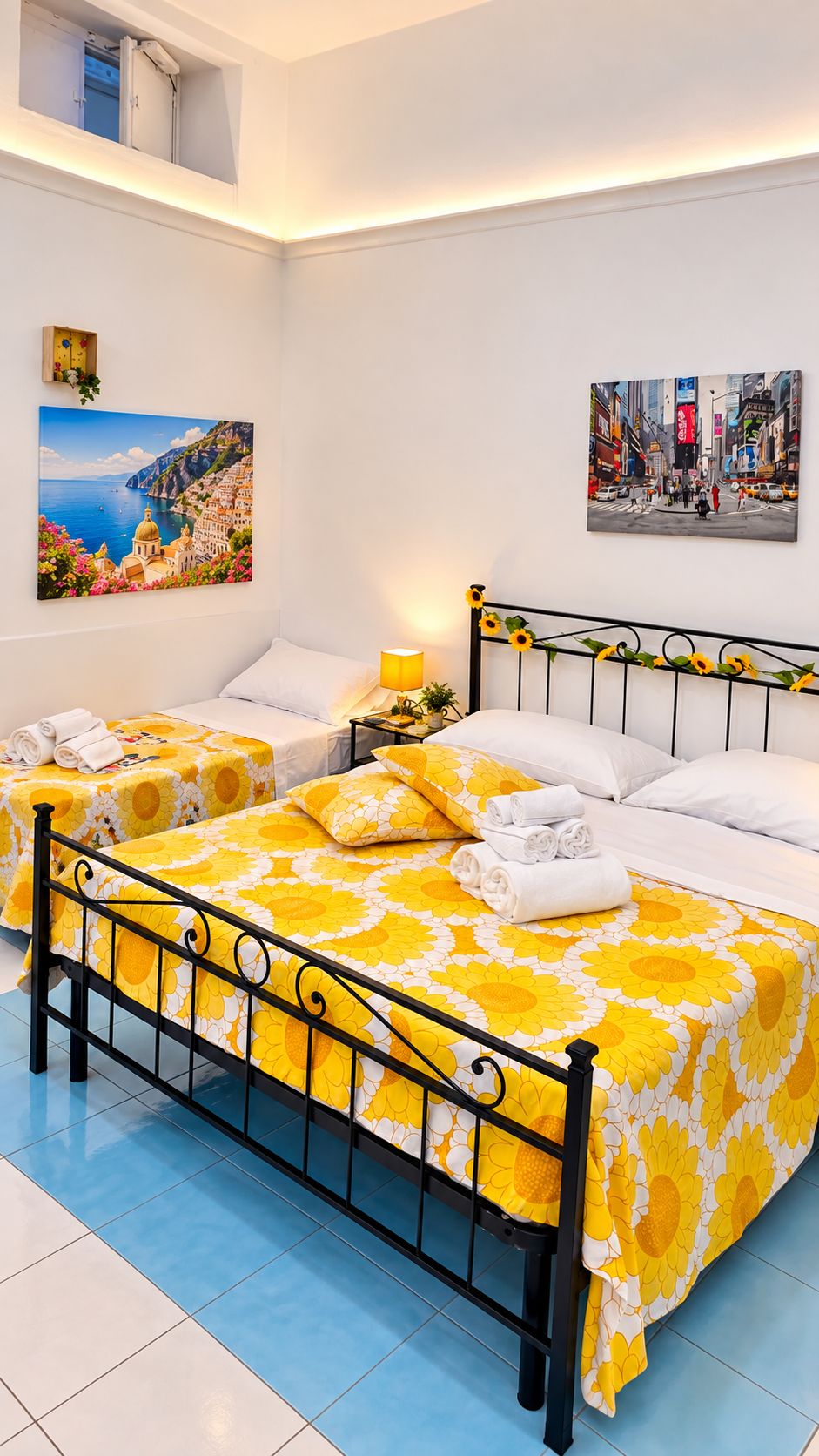 Habitación de hotel con dos camas, un balcón y obras de arte en las paredes.