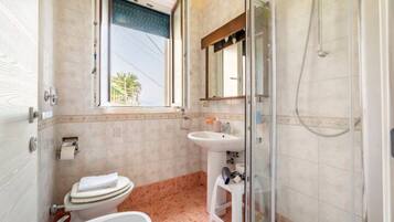 Ein Badezimmer mit Toilette, Waschbecken und Dusche.