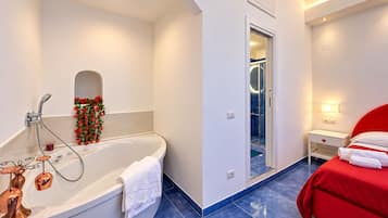 Un bagno moderno con una vasca, una doccia e un angolo doccia con pareti in vetro.