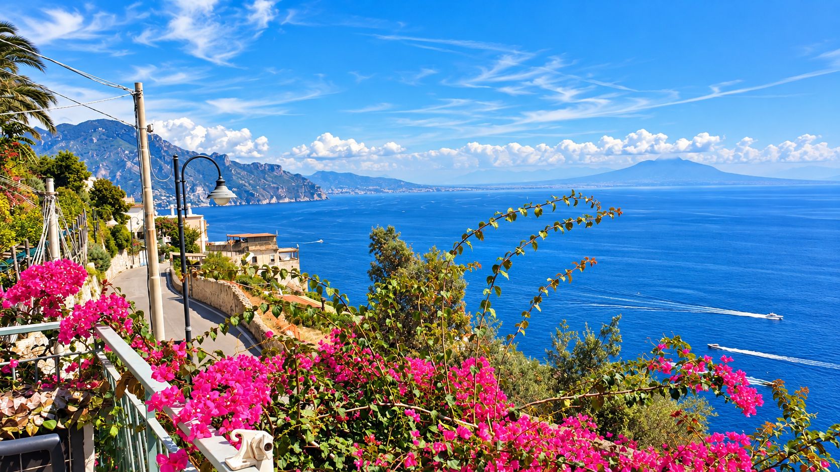 A coastal road with a view of the sea and mountains.