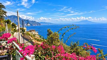 A coastal road with a view of the sea and mountains.