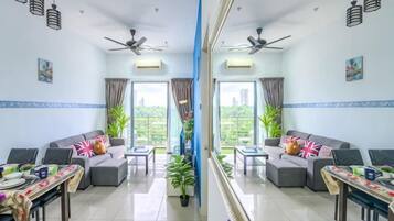 A mirrored room with two sofas, a dining table, ceiling fans, and large windows with curtains.