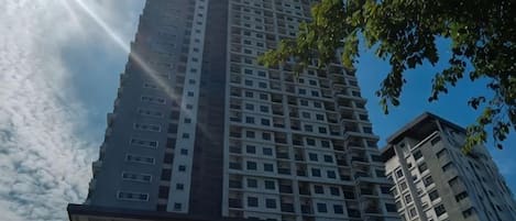 A high-rise building with multiple floors, large windows, and a clear sky.