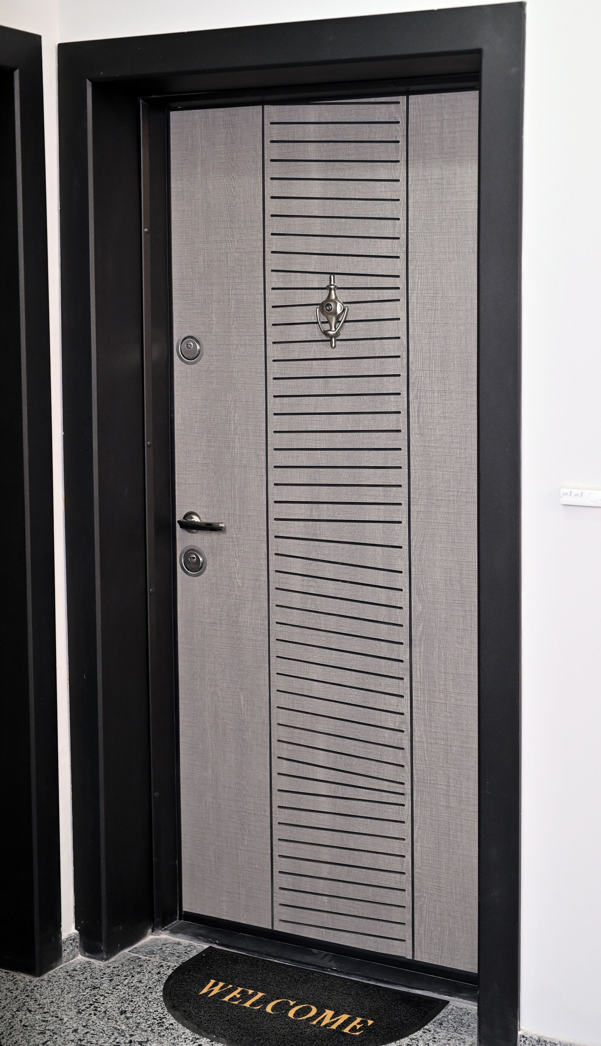 A modern door with horizontal lines, a keyhole, and a lock.